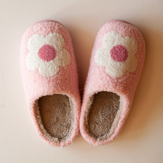 Cozy pink slippers featuring an embroidered white flower with a pink center, perfect for comfortable and cute indoor wear.