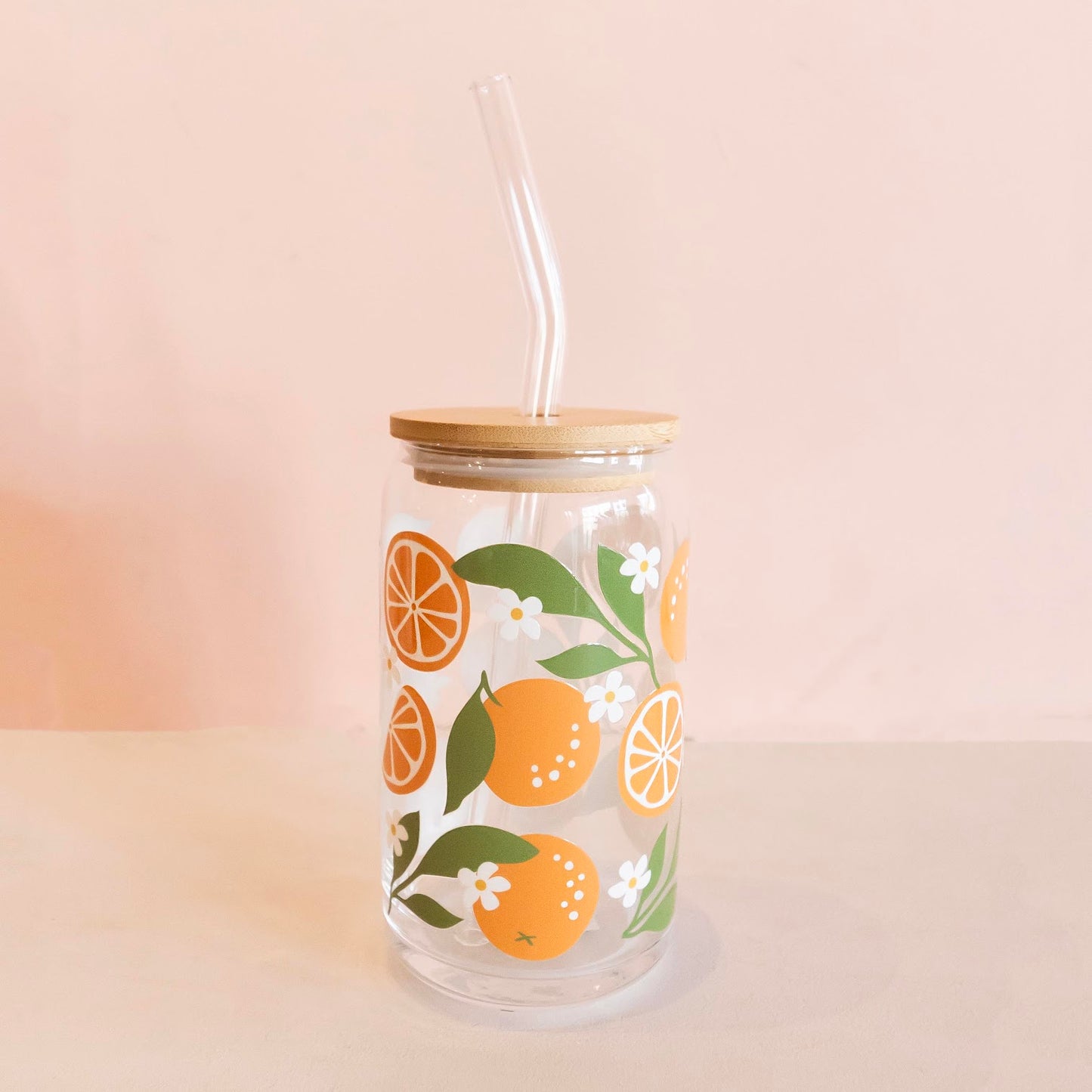 Eco-friendly glass tumbler featuring a vibrant orange blossom design, complete with a bamboo lid and glass straw, perfect for stylish and sustainable hydration