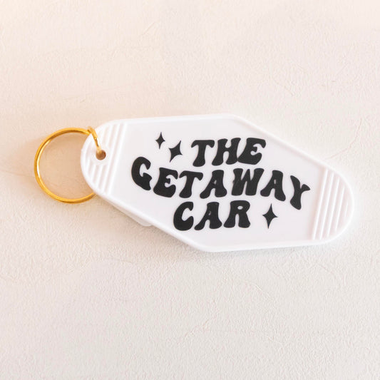 Vintage-inspired keychain with 'The Getaway Car' text and stars, made from white acrylic with a golden keyring. Perfect for adding a quirky, retro touch to your keys.