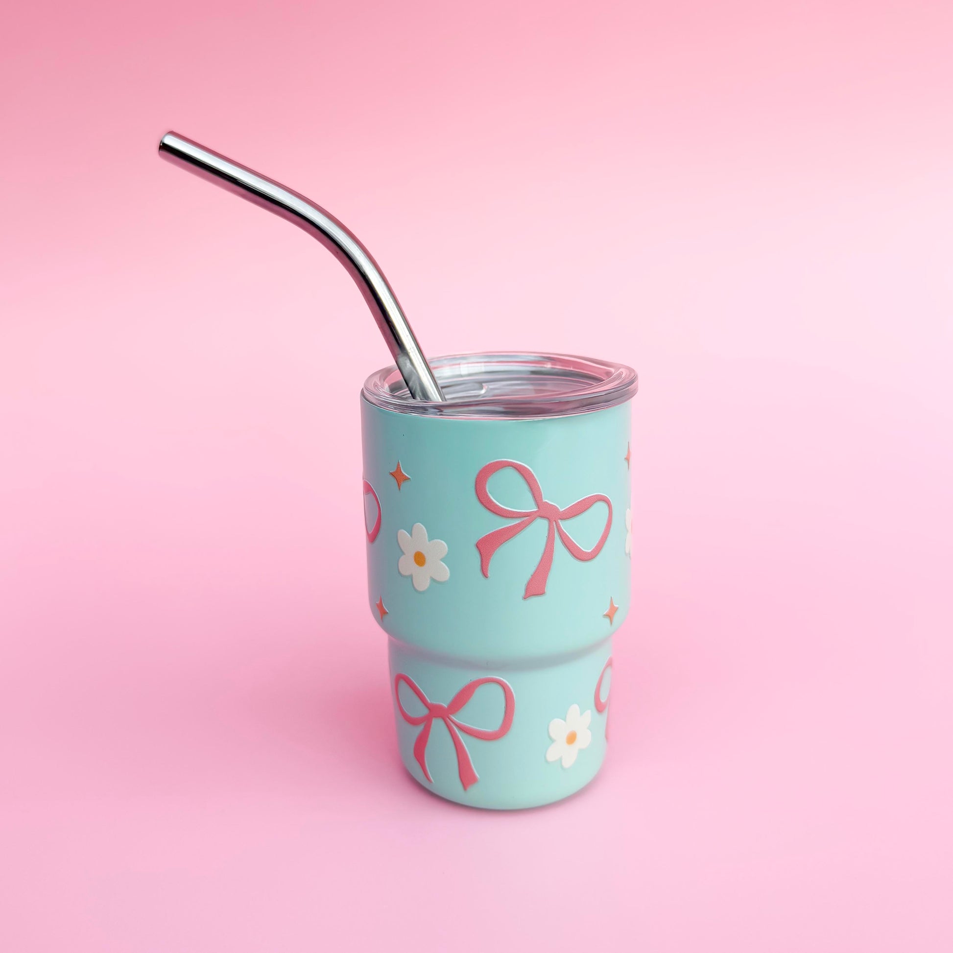 Small stainless mint colored steel cup with a pink bow and daisy  design, reusable straw, and spill-proof lid, ideal for Valentine’s Day gifts or party favors