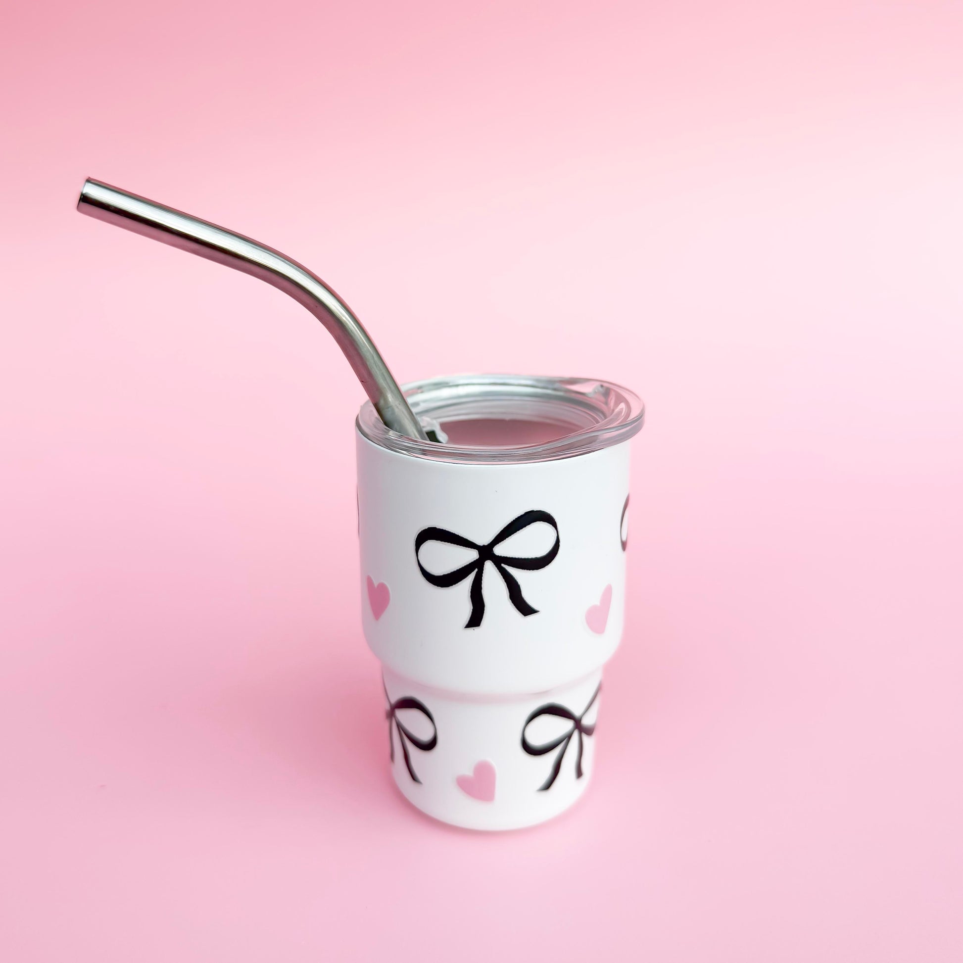 Small stainless steel white cup with a black bow design, reusable straw, and spill-proof lid, ideal for Valentine’s Day gifts or party favors