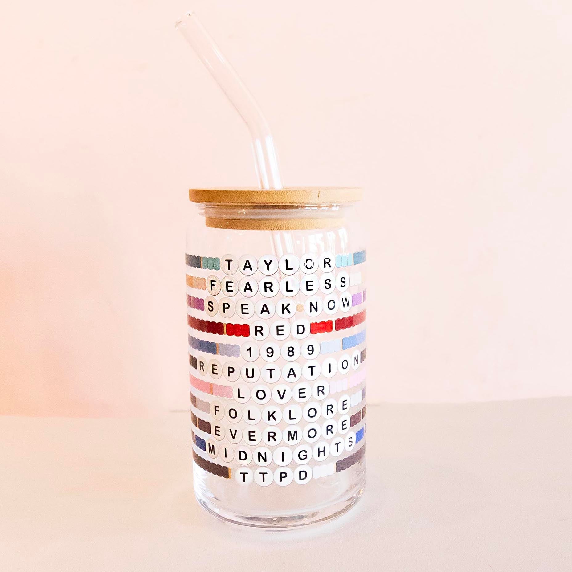 Taylor Swift Friendship glass tumbler with a reusable straw and bamboo lid, featuring designs of her album covers